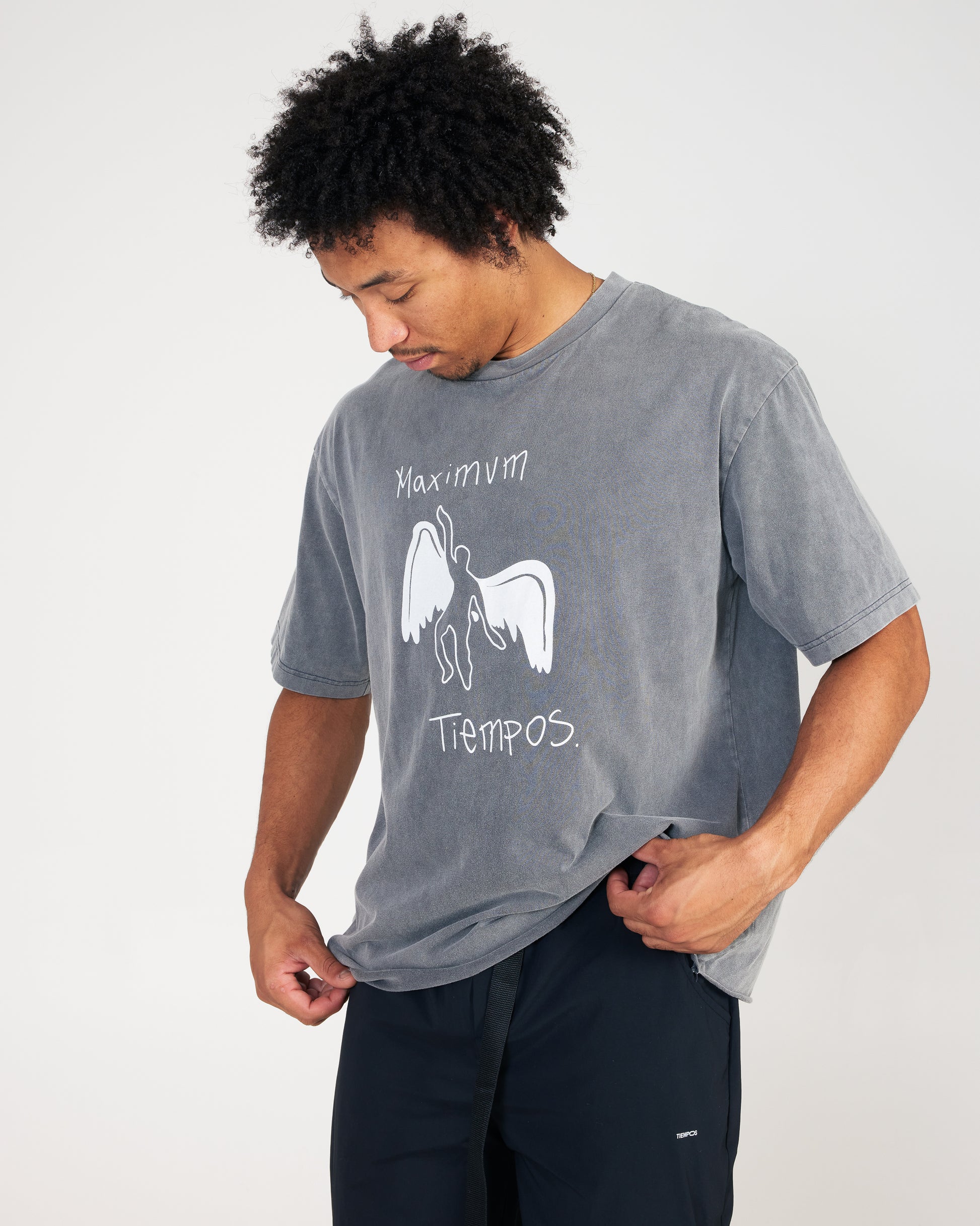 Person wearing a gray t-shirt with a graphic design on a white background