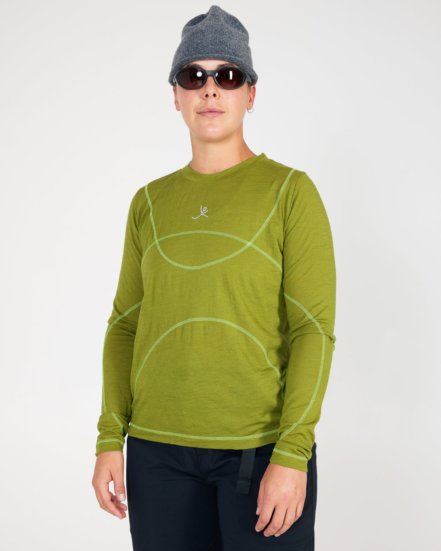 Person wearing a green long-sleeve shirt with a logo on a white background