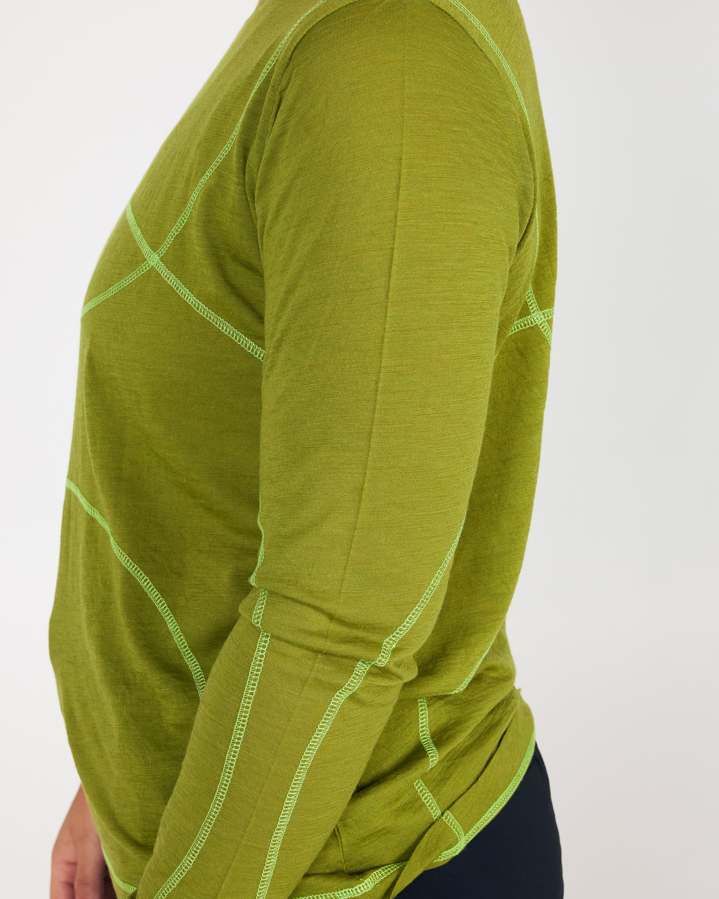 Green long-sleeve shirt with white stitching on a white background