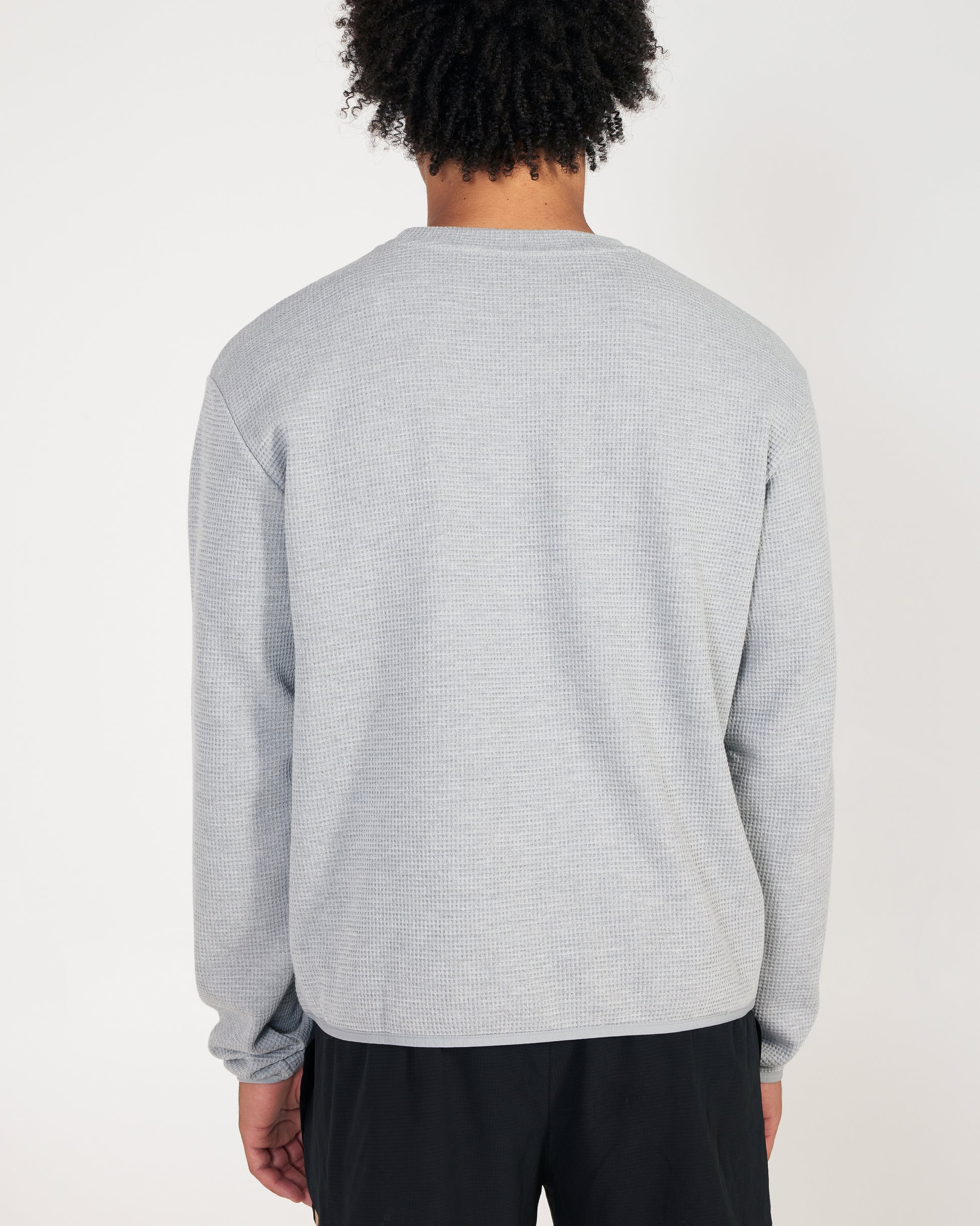 Person wearing a gray textured sweater on a white background