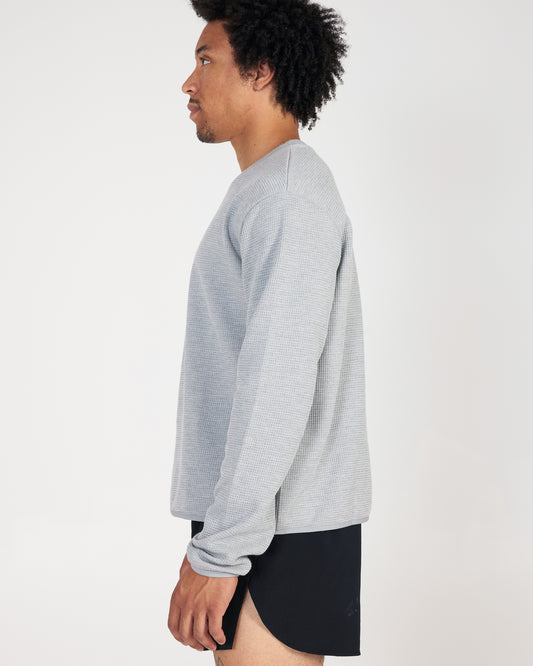 Person wearing a gray sweater on a white background