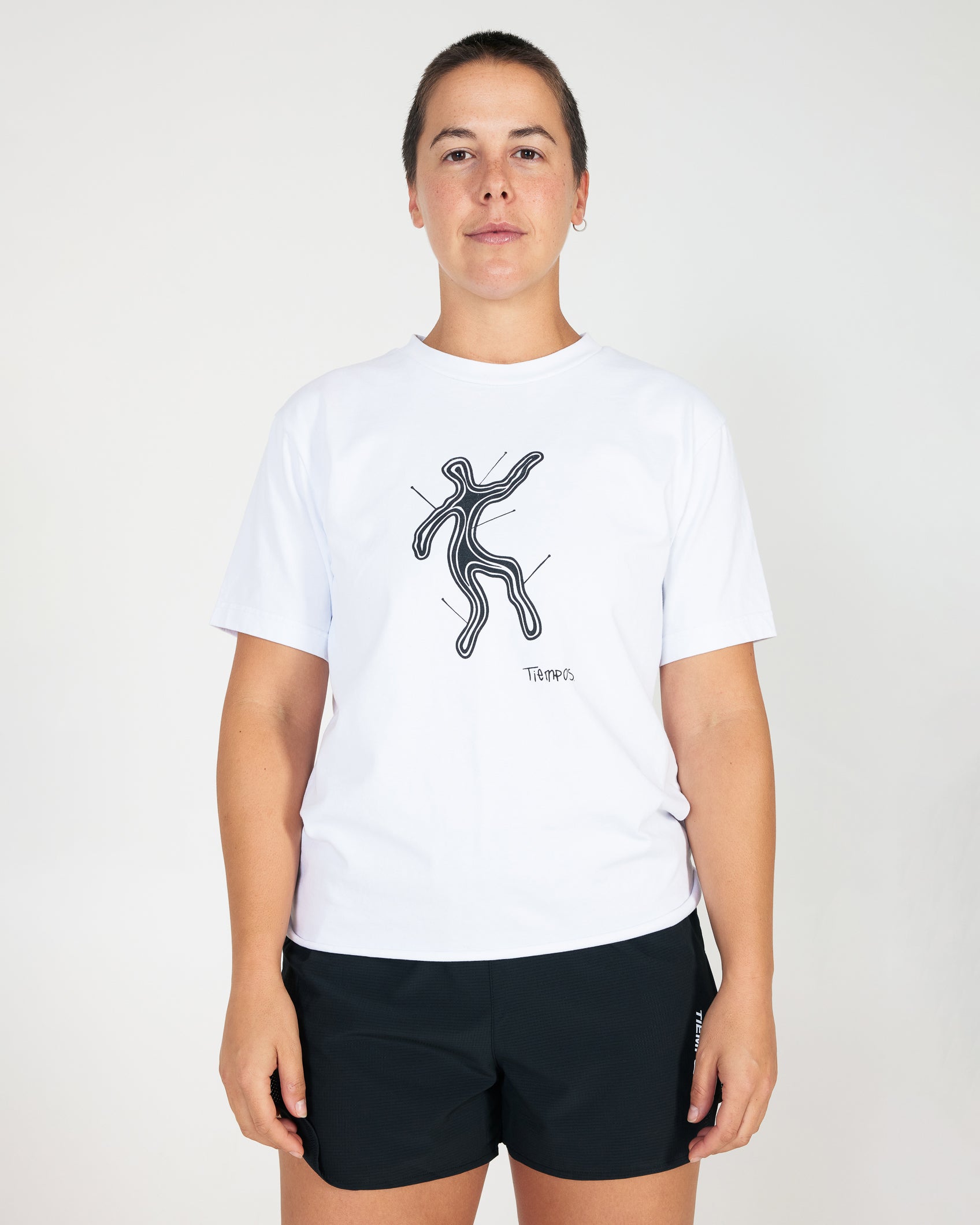 Person wearing a white t-shirt with a black graphic design on a plain background