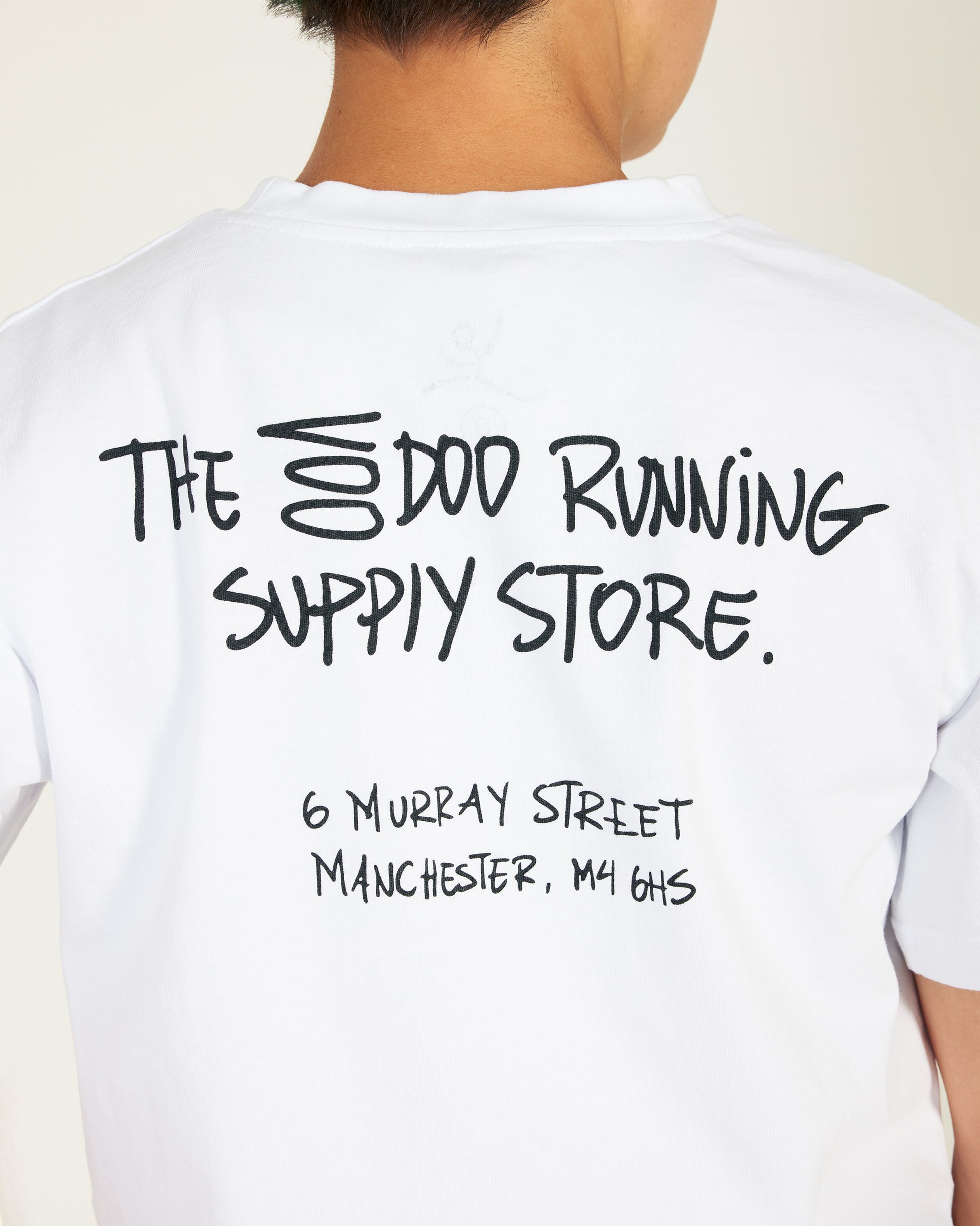 White t-shirt with black text on the back, featuring a store name and address.