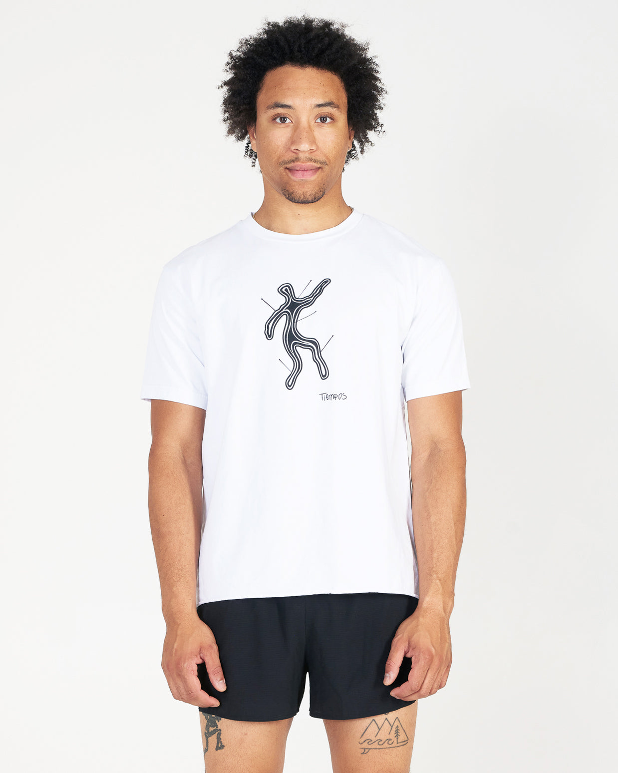 Man wearing a white t-shirt with a black graphic design on a plain background