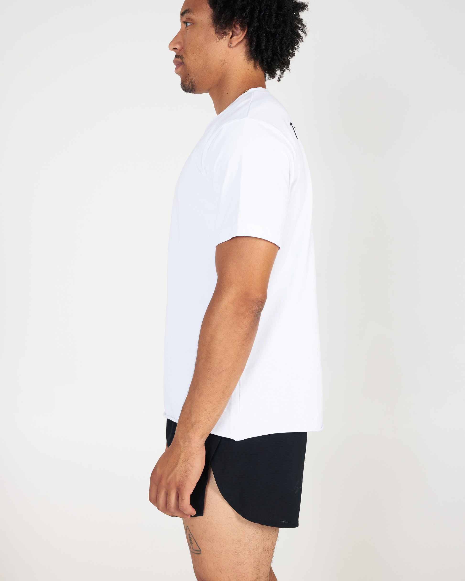 Person wearing a white t-shirt and black shorts on a plain background